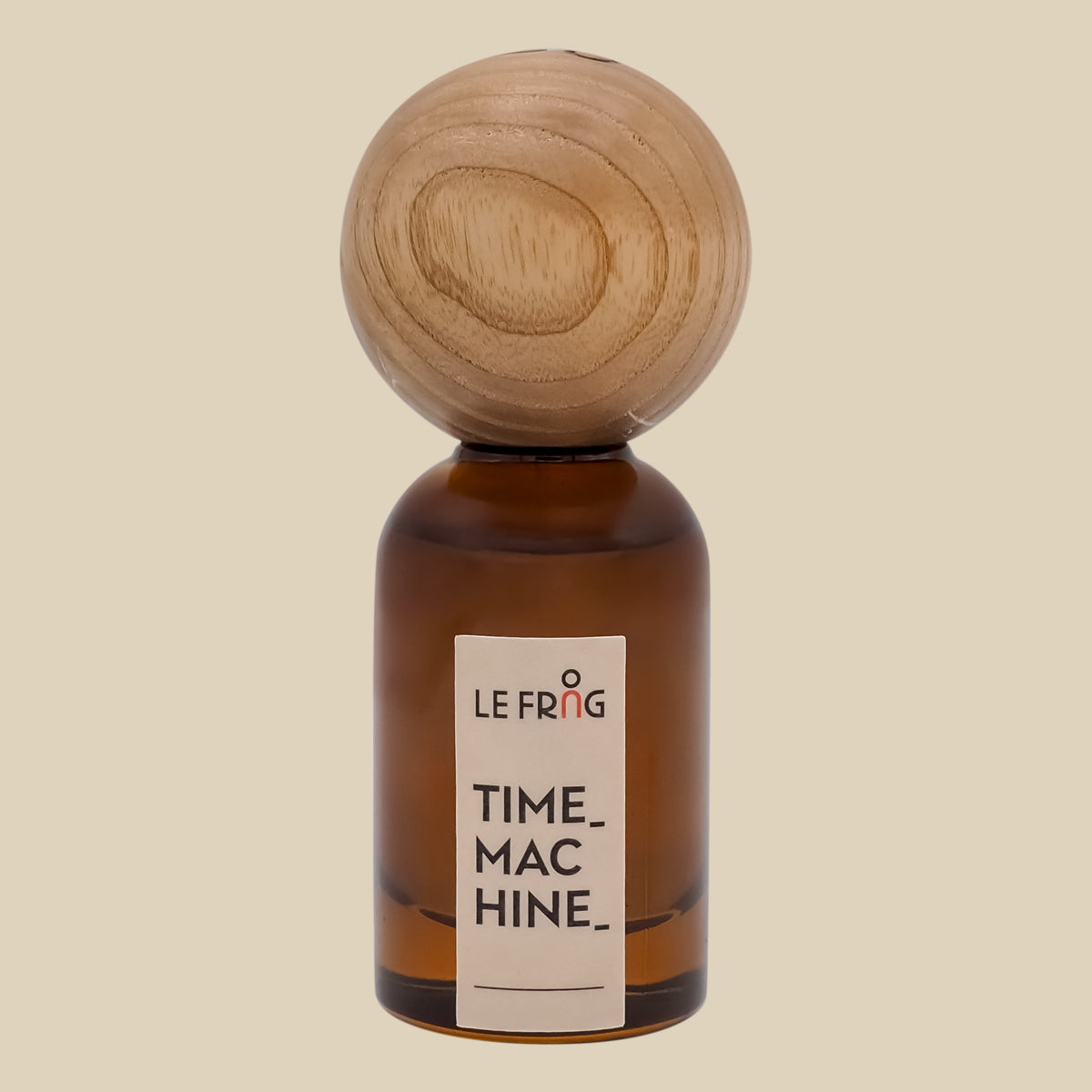 Le Frag Genesis perfume bottle with wooden cap on a beige background